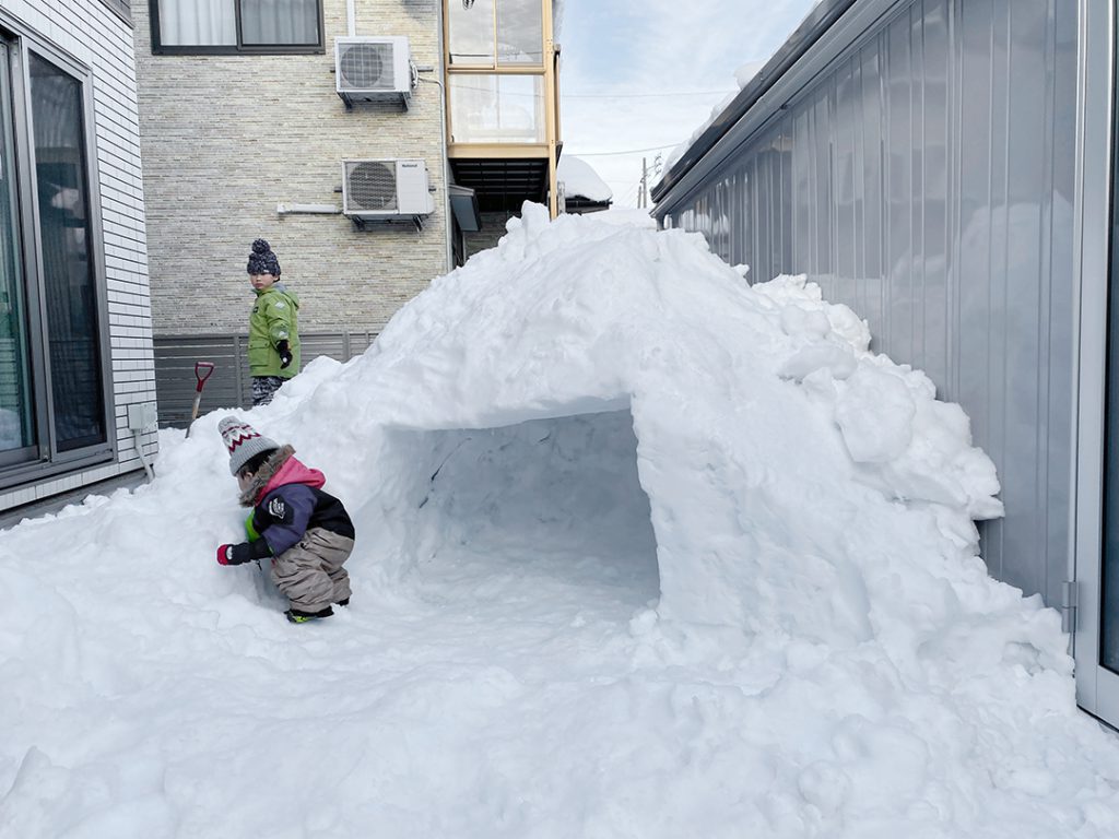 大雪で屋根から落とした雪でかまくらを作る